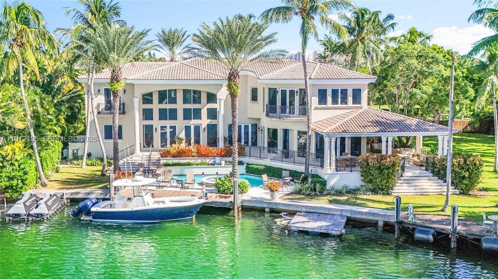 An aerial view shows waterfront homes surrounded by lush trees near a large bay — 550 Harbor Dr, Key Biscayne FL 33149, KEY BISCAYNE, FL