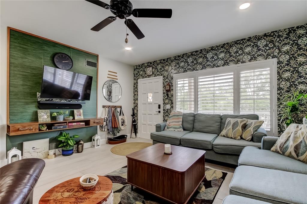 A kitchen features a granite-topped island with three stools and white cabinetry — 2170 AMERICUS BOULEVARD N UNIT 64, CLEARWATER, FL