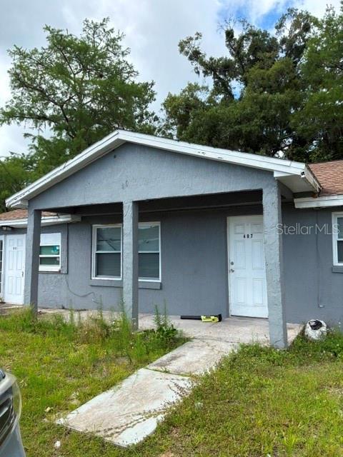A gray, single-story house exterior features a covered front porch and a concrete walkway — 407 S ANDERSON STREET, BUNNELL, FL