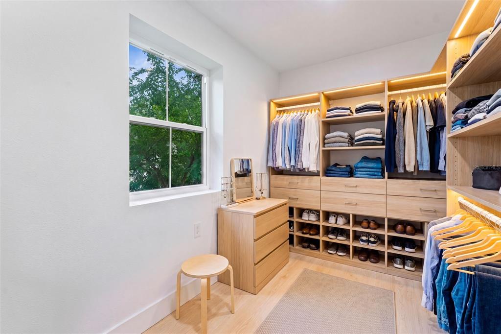 A walk-in closet features light wood cabinetry, hanging clothes, shelving, and a small vanity area — 802 W CORAL STREET, TAMPA, FL