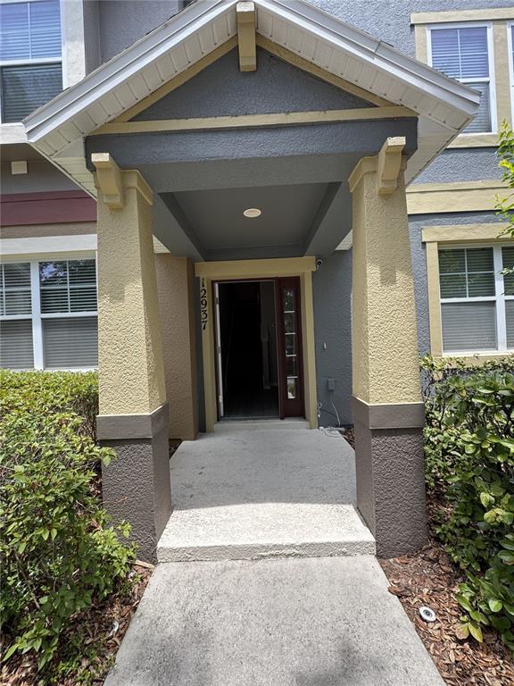 The exterior view shows a covered entryway with two pillars leading to a front door — 12937 EMERSONDALE AVENUE, WINDERMERE, FL