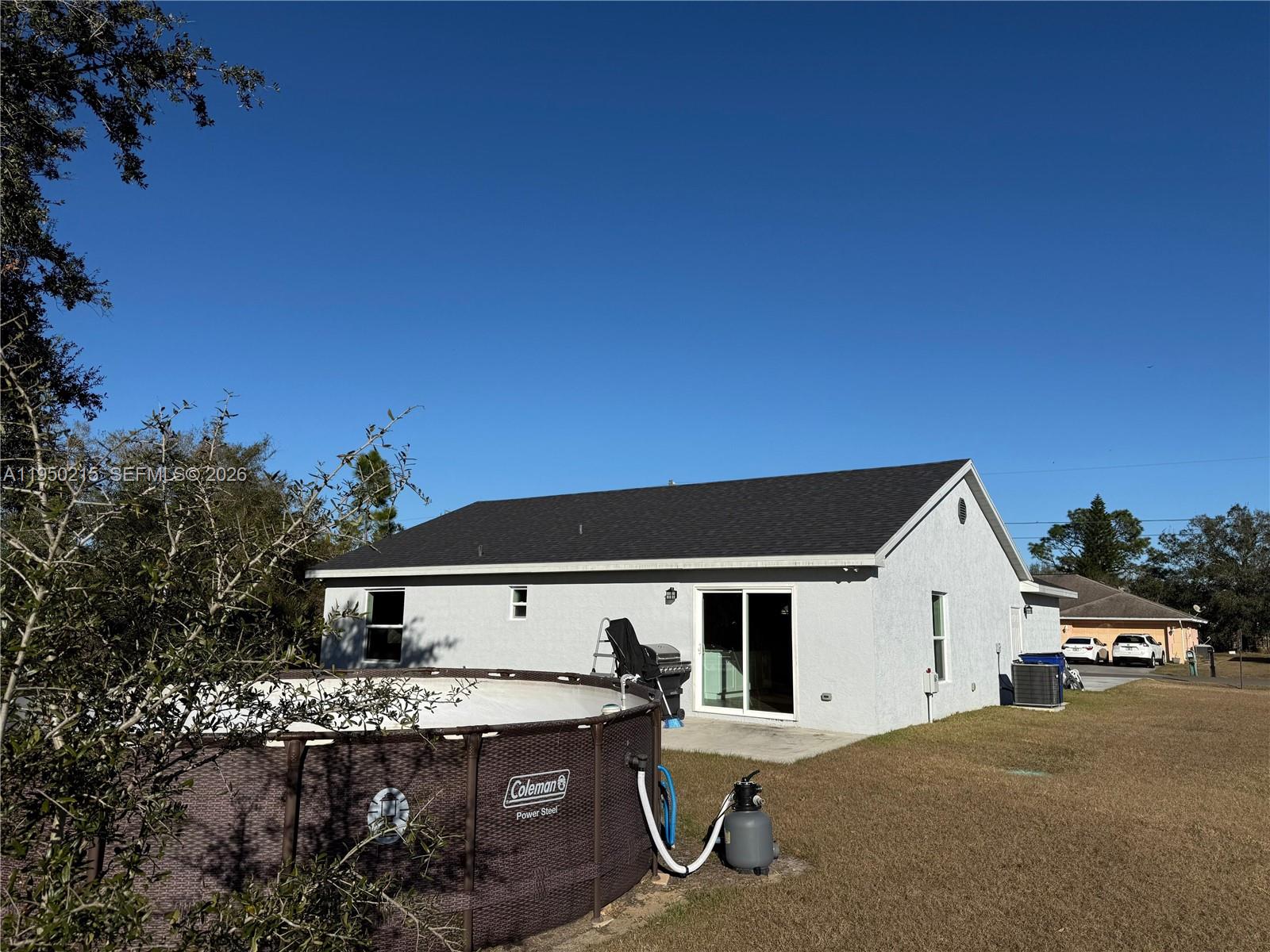 The exterior of a light-colored house features a dark roof and an above-ground swimming pool — 4103 Loretto Ave, Sebring FL 33872, SEBRING, FL
