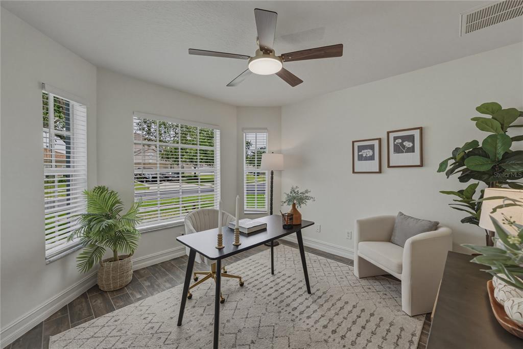 A home office features a desk, an armchair, a ceiling fan, and large windows — 4224 BRANCHSIDE LANE, WESLEY CHAPEL, FL