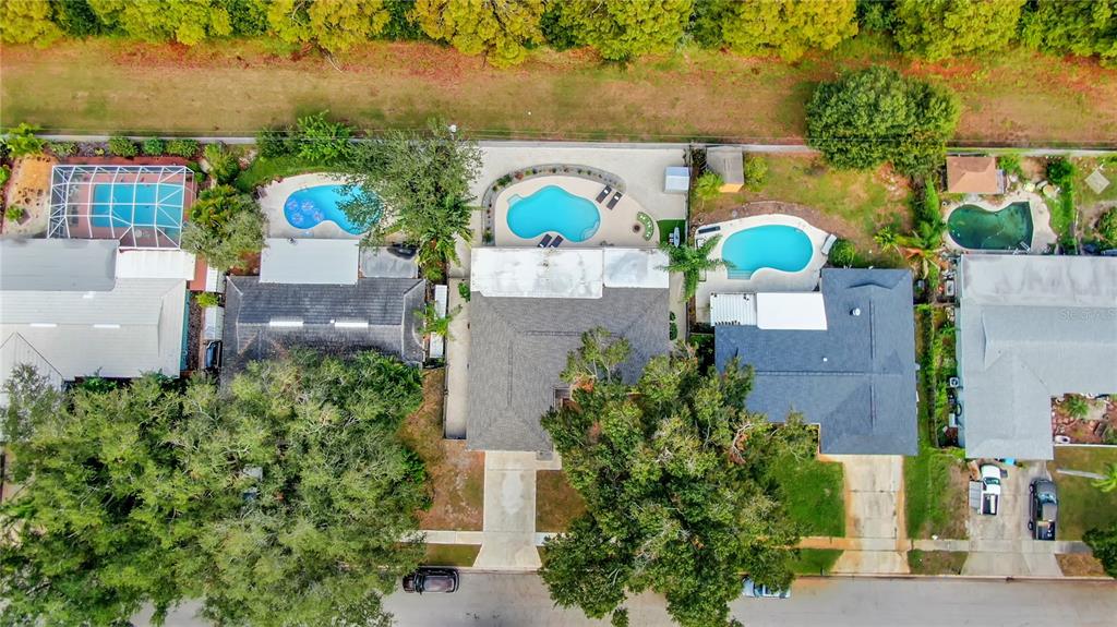 An aerial view shows four suburban houses with swimming pools and backyards along a street — 13347 88TH PLACE, SEMINOLE, FL