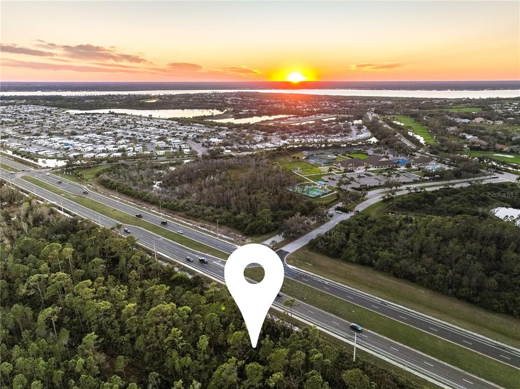 This is an aerial view of a wooded lot next to a highway at sunset — 3536 EL JOBEAN ROAD, PORT CHARLOTTE, FL