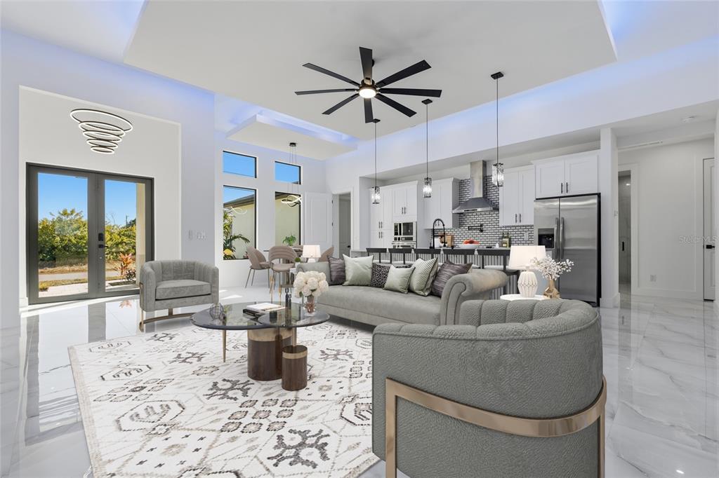 A modern open-concept living room features white tile floors, a coffered ceiling, and a kitchen — 1030 NE 2ND AVENUE, CAPE CORAL, FL