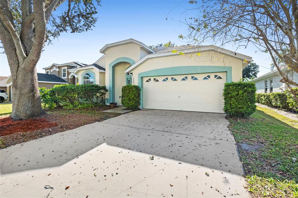 A single-story house with a beige stucco exterior, teal trim, and a two-car garage — 2640 HERON LANDING COURT, ORLANDO, FL