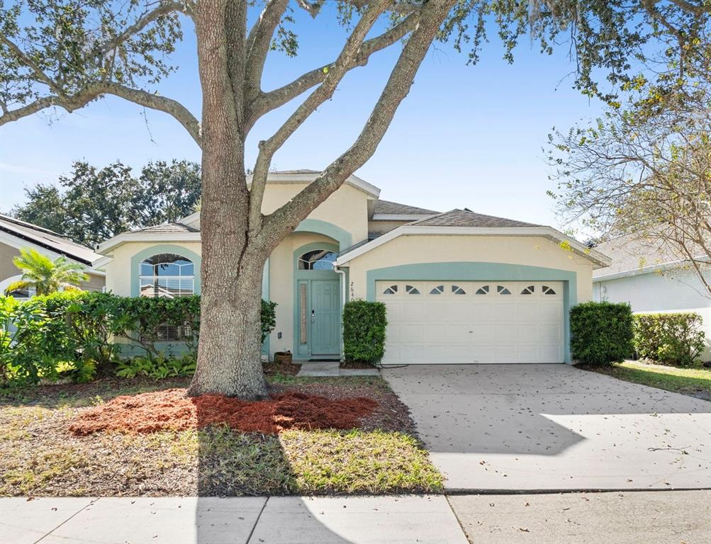 A single-story house with a light-colored stucco exterior, teal trim, and a large front tree — 2640 HERON LANDING COURT, ORLANDO, FL