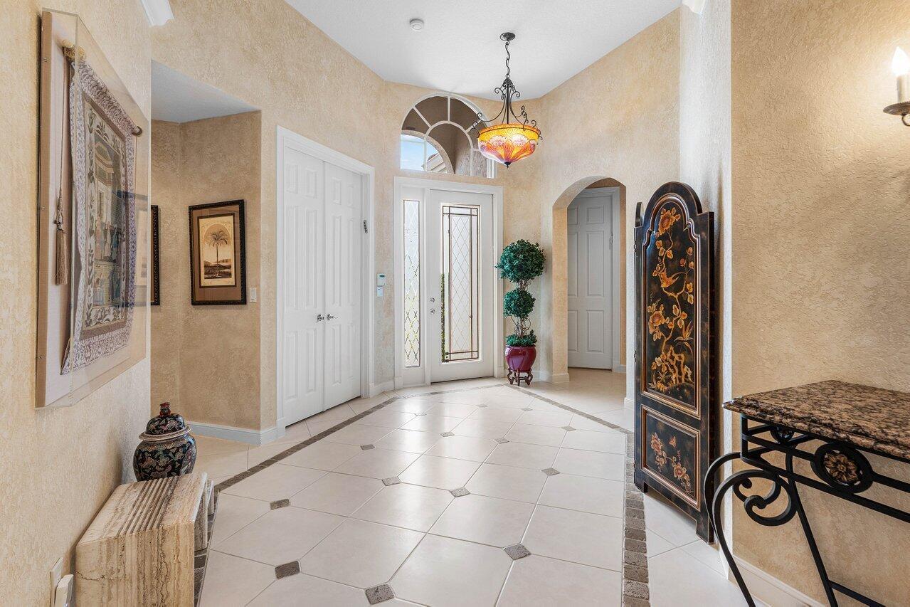 A tiled entryway features a decorative screen, a pendant light, and a front door — 6263 NW 43rd Terrace, Boca Raton FL 33496, BOCA RATON, FL