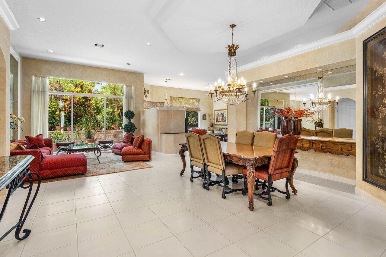 A dining area and living room with tile floors, a crystal chandelier, and large windows — 6263 NW 43rd Terrace, Boca Raton FL 33496, BOCA RATON, FL