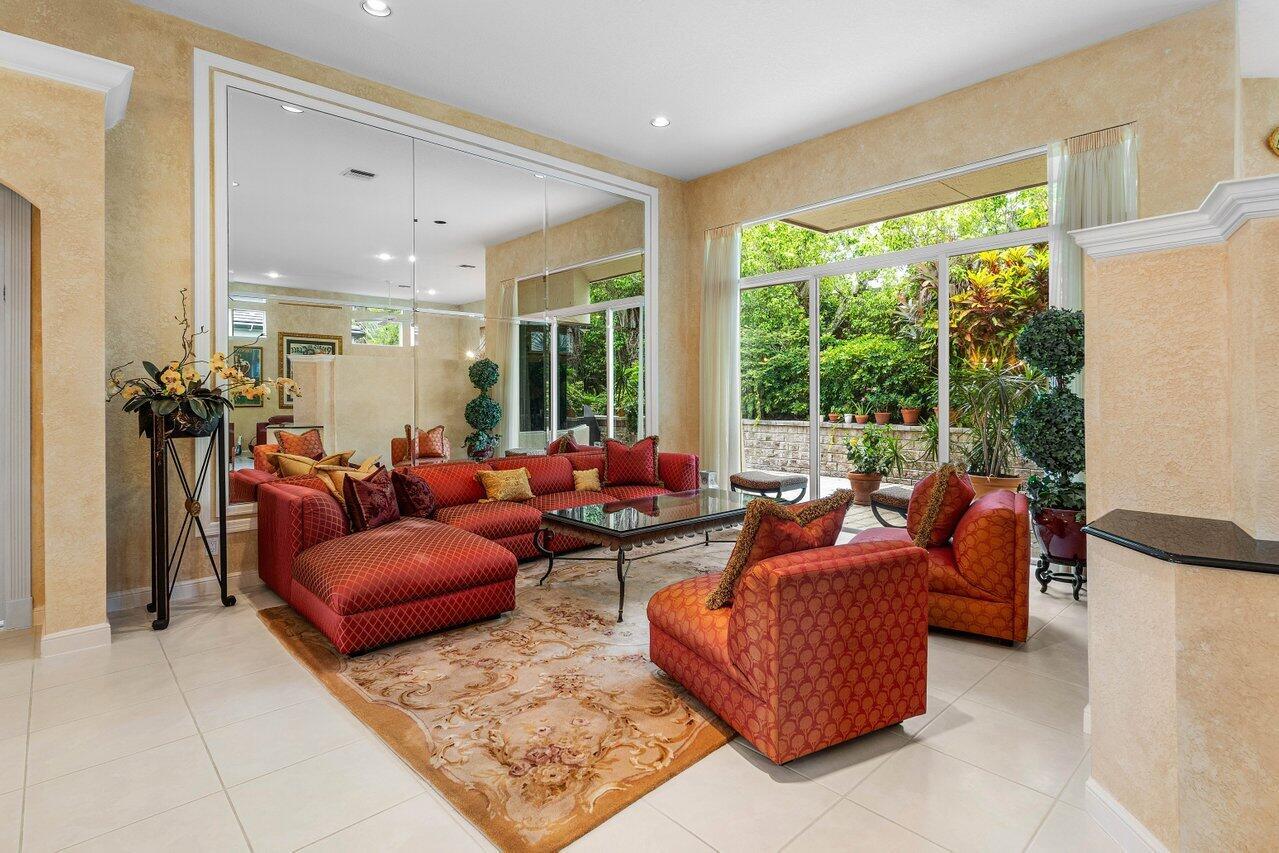 A living room features a large sectional sofa, a mirrored wall, and floor-to-ceiling windows — 6263 NW 43rd Terrace, Boca Raton FL 33496, BOCA RATON, FL