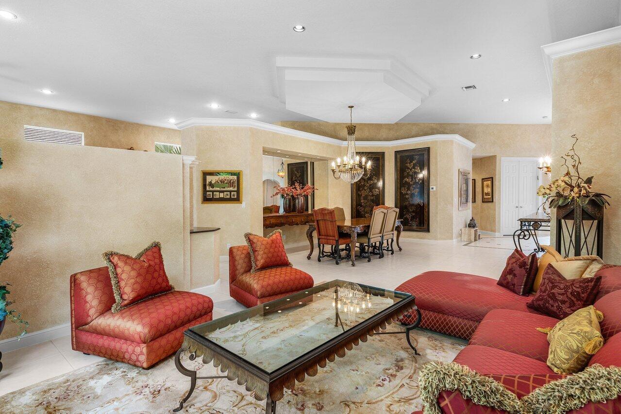 A living room with red furniture, a glass coffee table, and a dining area beyond — 6263 NW 43rd Terrace, Boca Raton FL 33496, BOCA RATON, FL