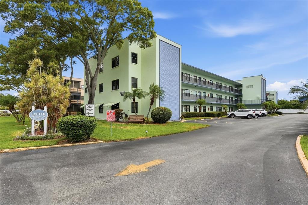 A three-story apartment building with a light green exterior and a blue tiled accent wall — 5973 TERRACE PARK DRIVE N UNIT 109, ST PETERSBURG, FL