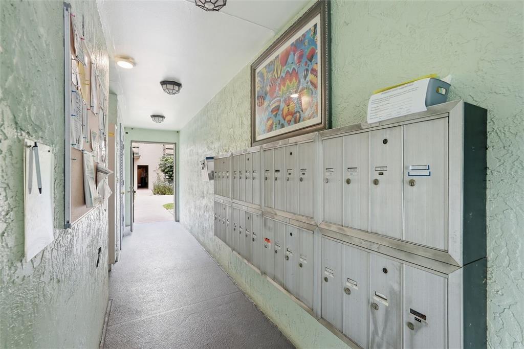 A concrete patio with a stone table sits outside a multi-story apartment building — 5973 TERRACE PARK DRIVE N UNIT 109, ST PETERSBURG, FL