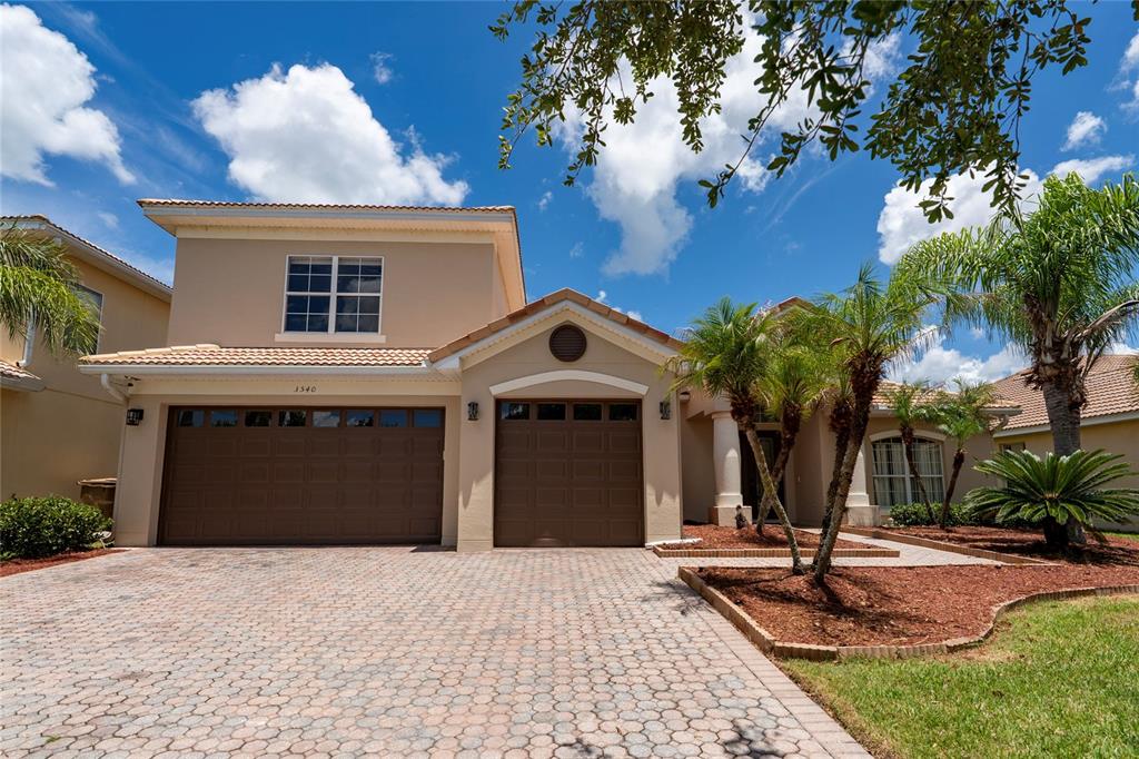 A two-story suburban house with a paved driveway, two-car garage, and palm trees — 3540 VALLEYVIEW DR, KISSIMMEE, FL