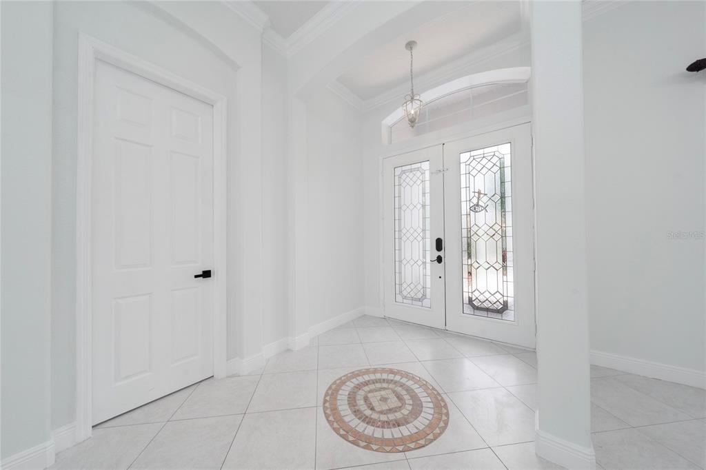 A bright entryway features white tile floors, a decorative medallion, and double glass-paneled front doors — 3540 VALLEYVIEW DR, KISSIMMEE, FL
