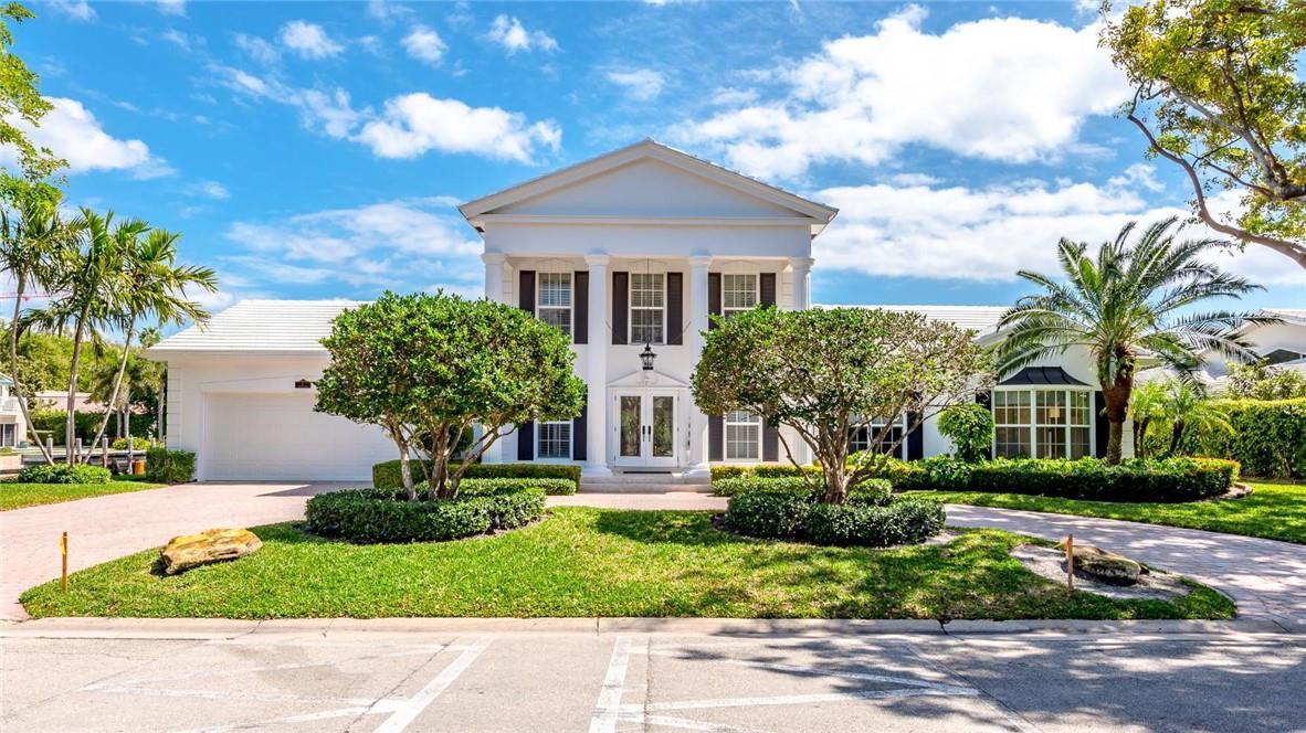 A two-story white house with a pedimented portico and columns stands behind a manicured lawn — 2 Compass Lane, Fort Lauderdale FL 33308, FORT LAUDERDALE, FL