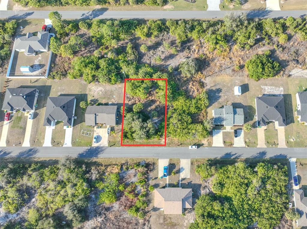 An aerial view shows a vacant, rectangular residential lot outlined in red between two houses — 11200 KIMBERLY AVENUE, ENGLEWOOD, FL