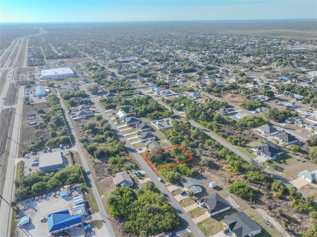 An aerial view shows a vacant, rectangular lot outlined in red within a residential neighborhood — 11200 KIMBERLY AVENUE, ENGLEWOOD, FL