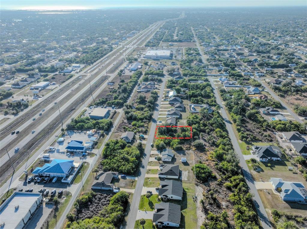 An aerial view shows a vacant, rectangular lot outlined in red within a residential neighborhood — 11200 KIMBERLY AVENUE, ENGLEWOOD, FL