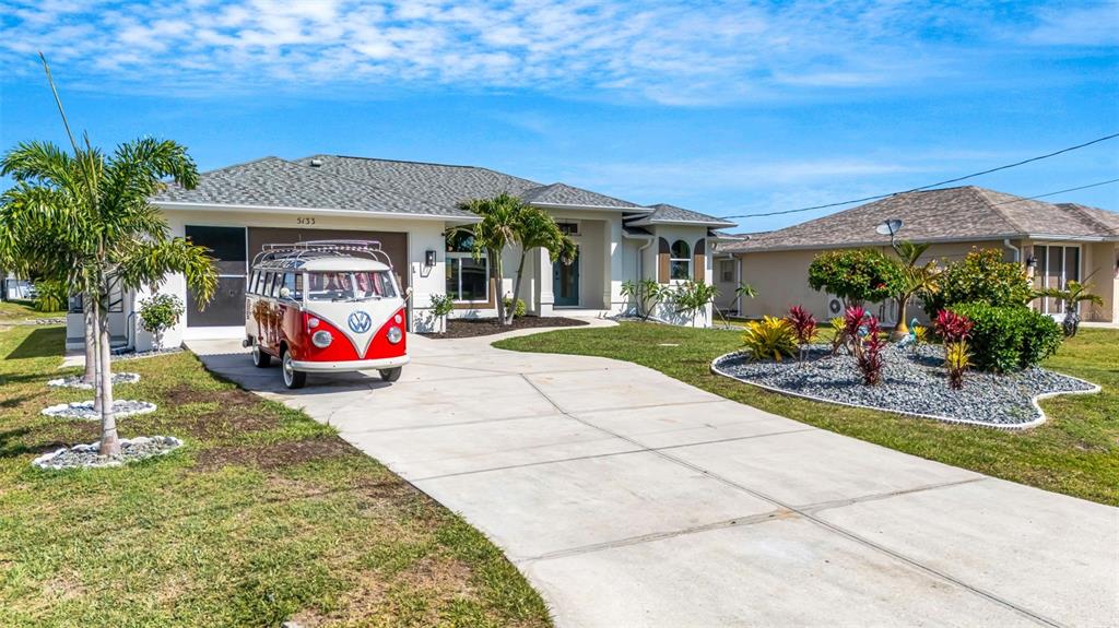 A red and white vintage Volkswagen bus is parked in the driveway of a house — 5133 LATHAM TERRACE, PORT CHARLOTTE, FL