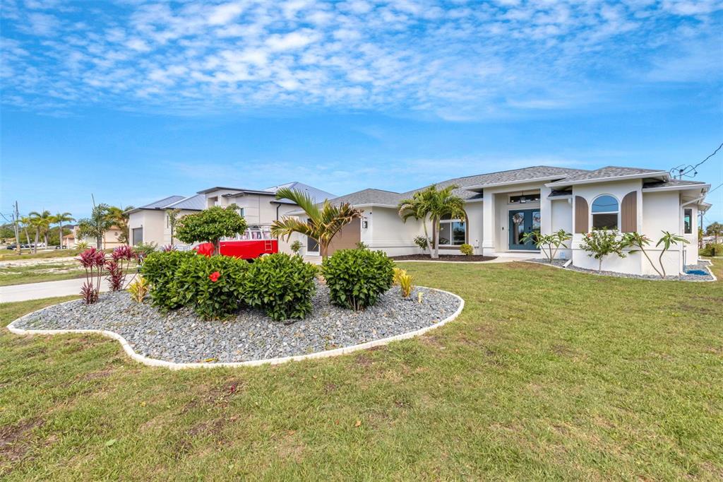 A single-story house with a gray shingled roof, white exterior, and a landscaped front yard — 5133 LATHAM TERRACE, PORT CHARLOTTE, FL