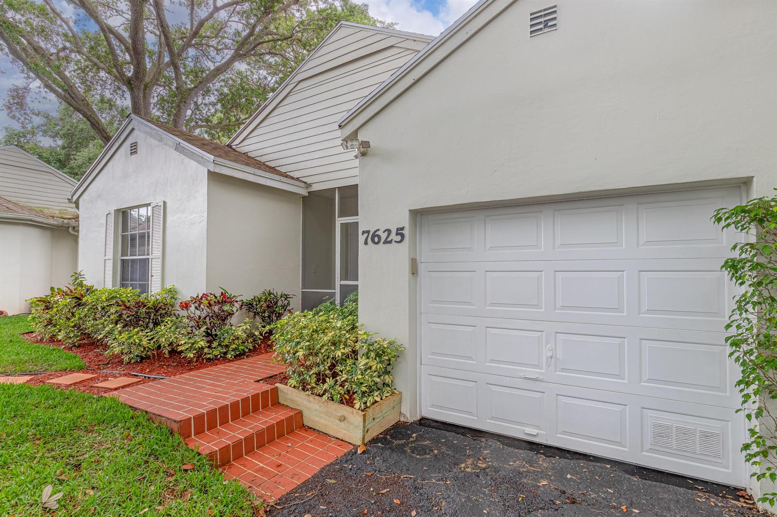 A single-story house with a white stucco exterior, a garage, and red brick steps — 7625 Forest Green Lane, Boynton Beach FL 33436, BOYNTON BEACH, FL