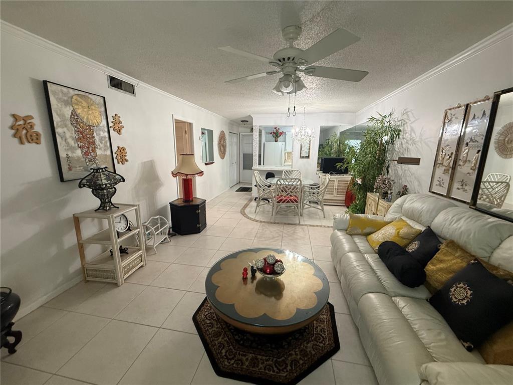A living room features white tile floors, a ceiling fan, and a dining area beyond — 125 PICARDY VILLA CIRCLE UNIT 101, BRANDON, FL