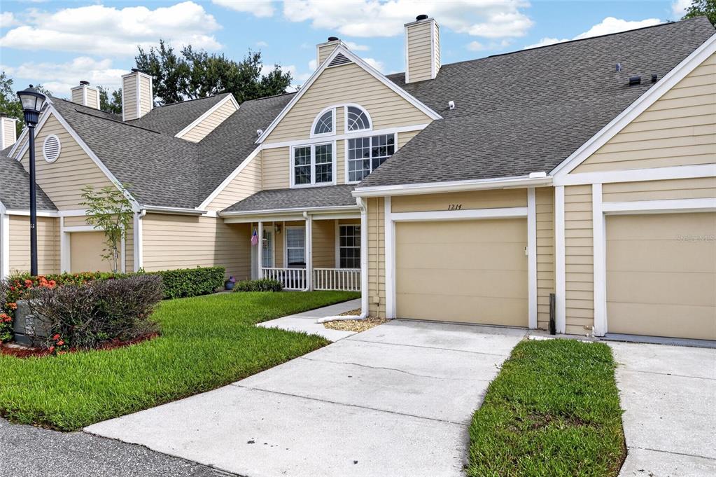 A tan two-story townhouse with a gray shingled roof and a concrete driveway — 1214 BIG PINE DRIVE, VALRICO, FL
