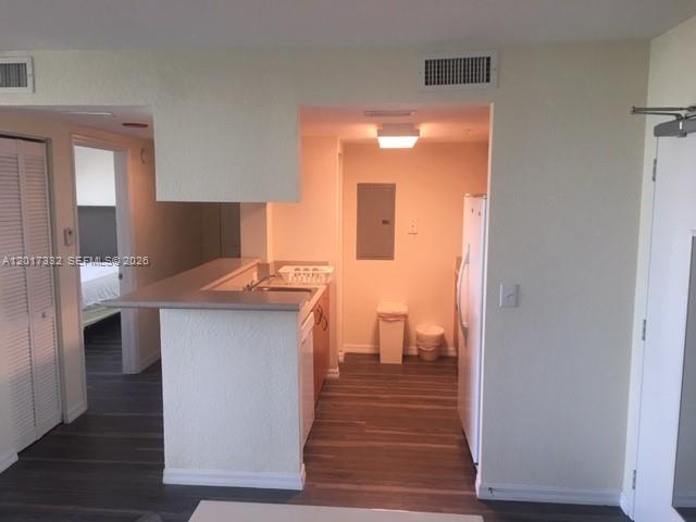 A kitchen with a breakfast bar, wood-look flooring, and a white refrigerator — 816 NW 11th St # 1104, Miami FL 33136, MIAMI, FL