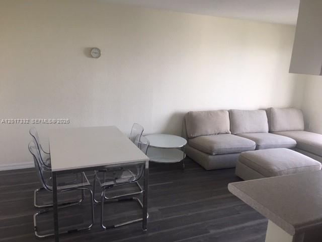 A living and dining area features a light-colored sofa, a dining table, and dark flooring — 816 NW 11th St # 1104, Miami FL 33136, MIAMI, FL
