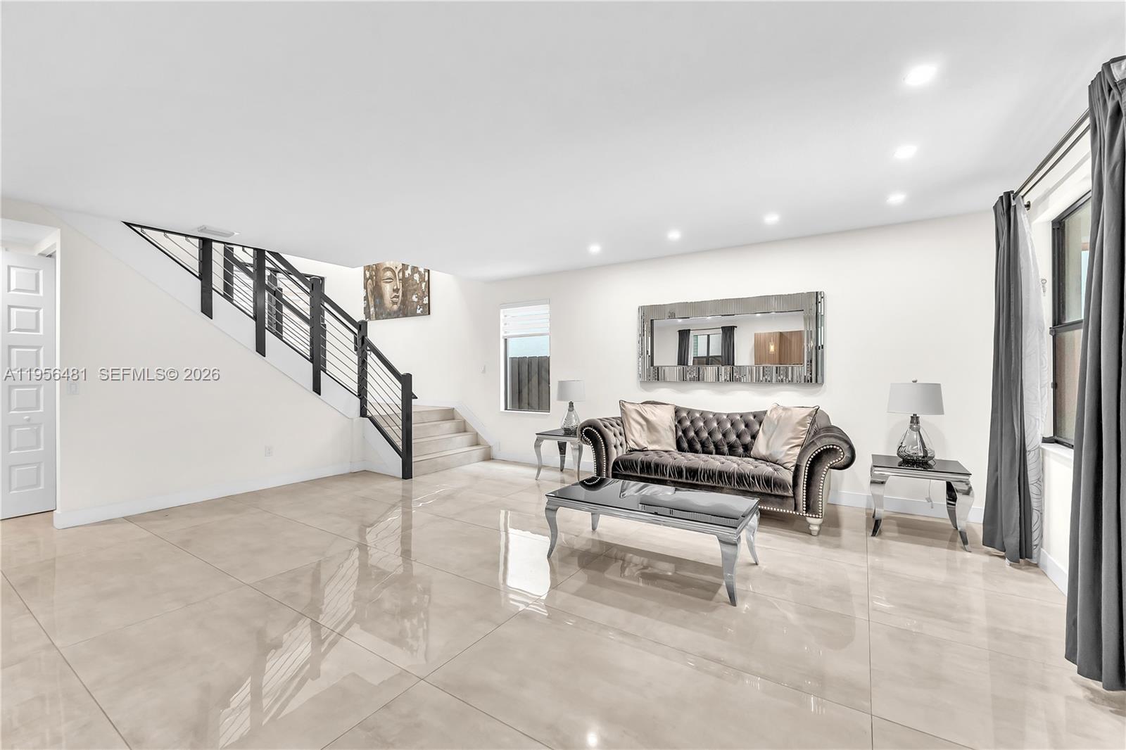 A living room features a tufted gray sofa, a glass coffee table, and a staircase — 10250 NW 76th Ter, Doral FL 33178, DORAL, FL