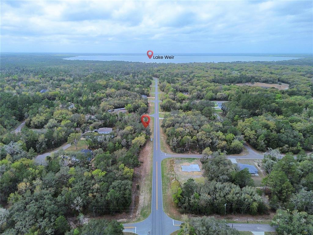 An aerial view shows a road leading toward Lake Weir with a marked property lot — TBD BAY ROAD, OCKLAWAHA, FL