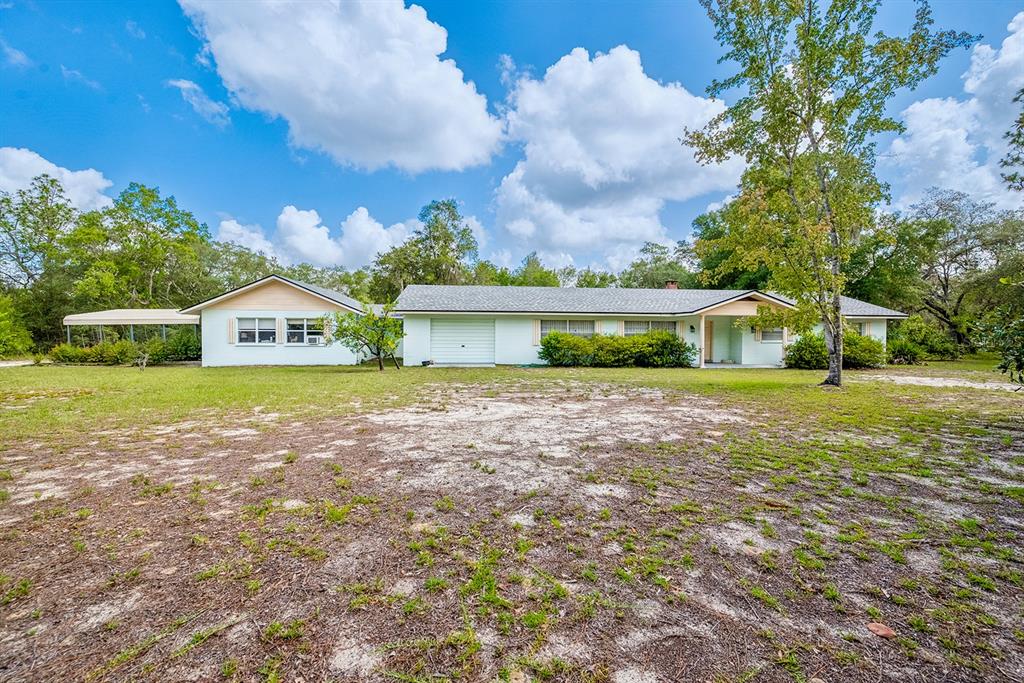 A single-story house with a white exterior, a garage, and a large front yard — 6267 CLANCE ROAD, KEYSTONE HEIGHTS, FL