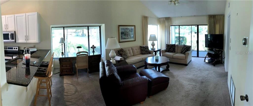 A panoramic view shows a living room with a kitchen island and a desk area — 5358 MYRTLE UNIT 52, SARASOTA, FL