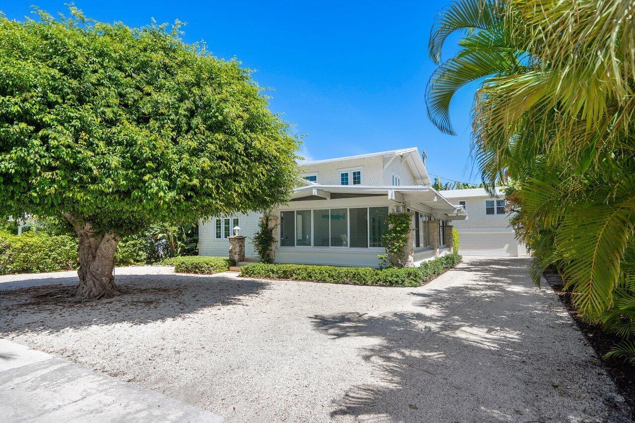 A white house with a gravel driveway, a large tree, and a glass-enclosed porch — 141 Chilean Avenue, Palm Beach FL 33480, PALM BEACH, FL