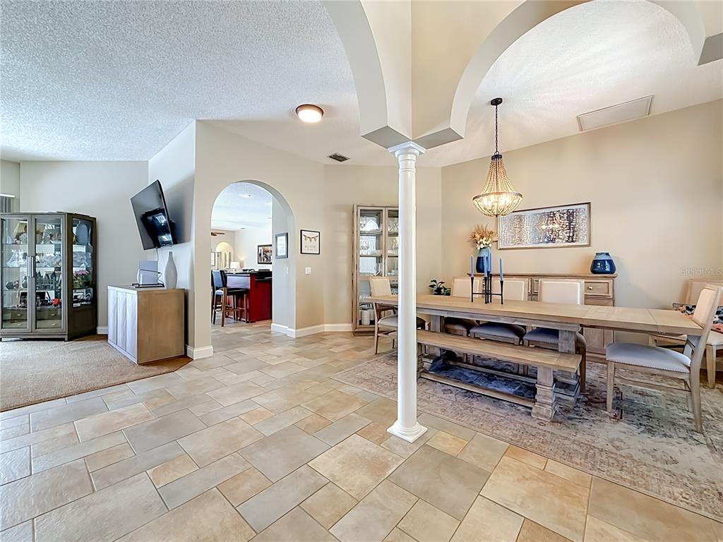 A dining area with a wooden table and bench features a central white support column — 1266 BERKSHIRE LANE, TARPON SPRINGS, FL