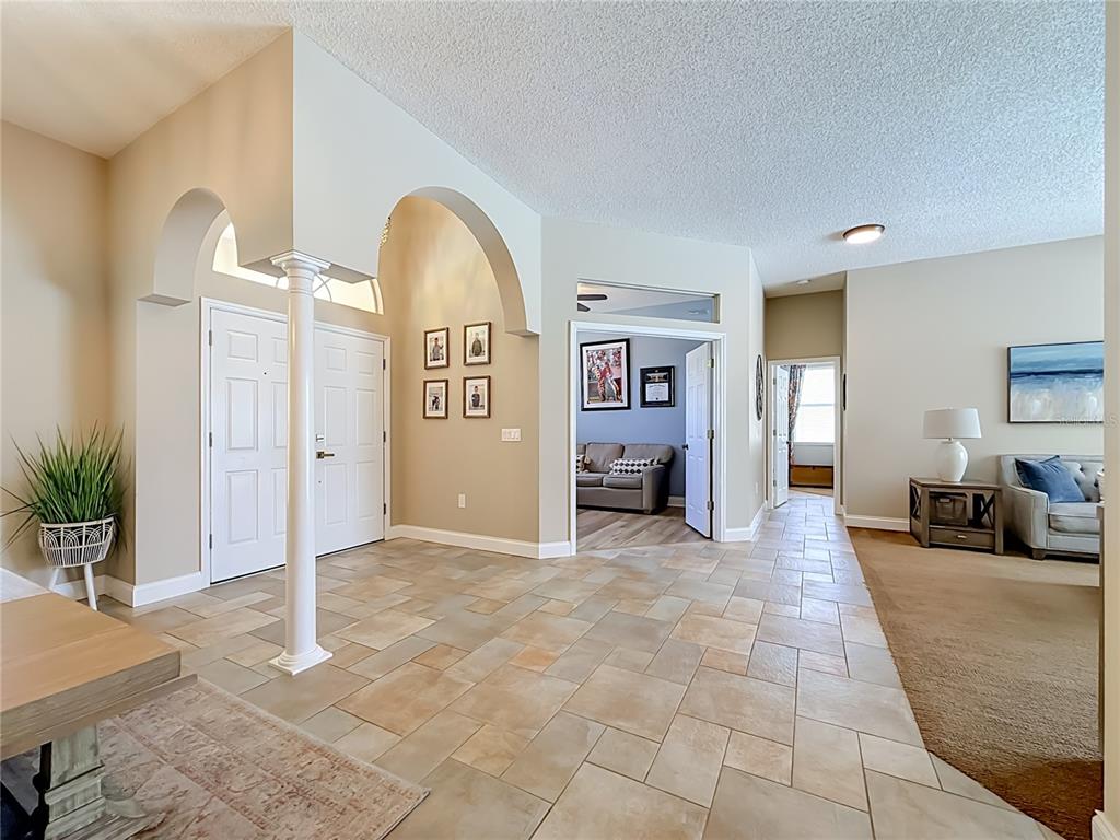 A tiled entryway features arched doorways, a white column, and views into adjacent living spaces — 1266 BERKSHIRE LANE, TARPON SPRINGS, FL