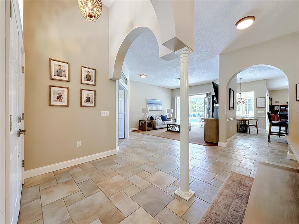 A tiled entryway features arched openings, a central column, and a view into the living area — 1266 BERKSHIRE LANE, TARPON SPRINGS, FL