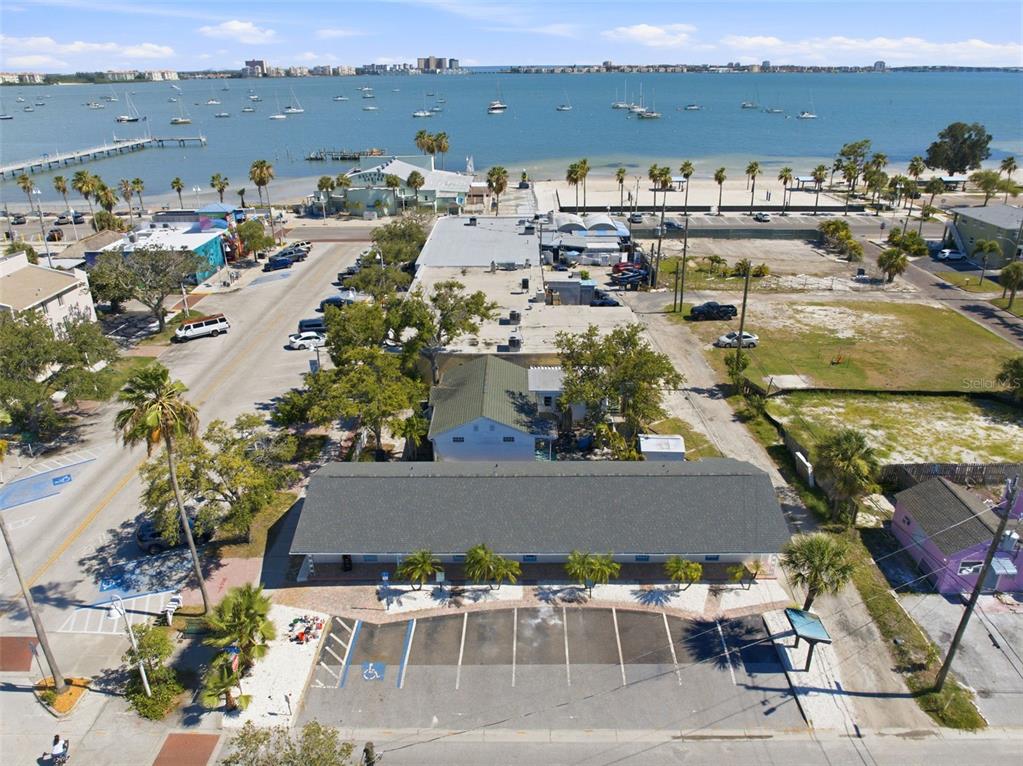 An aerial view shows a commercial building with a parking lot near a waterfront — 3101 BEACH BOULEVARD S UNIT 1-5, GULFPORT, FL