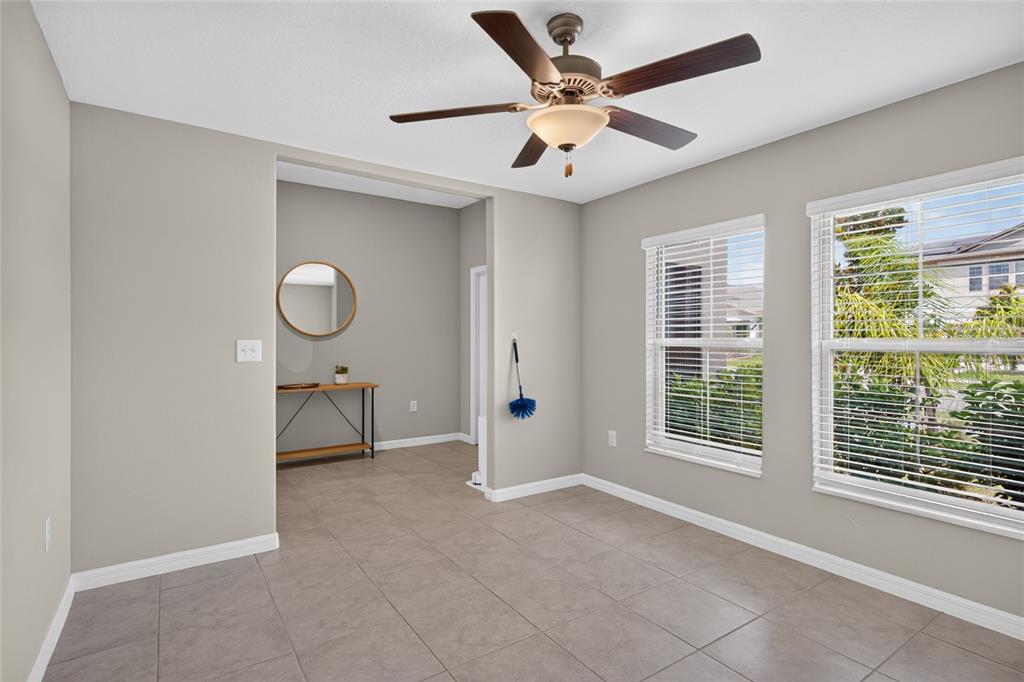 A room with light gray walls, tile flooring, a ceiling fan, and two windows — 5420 LESLIE CANYON DRIVE, WIMAUMA, FL