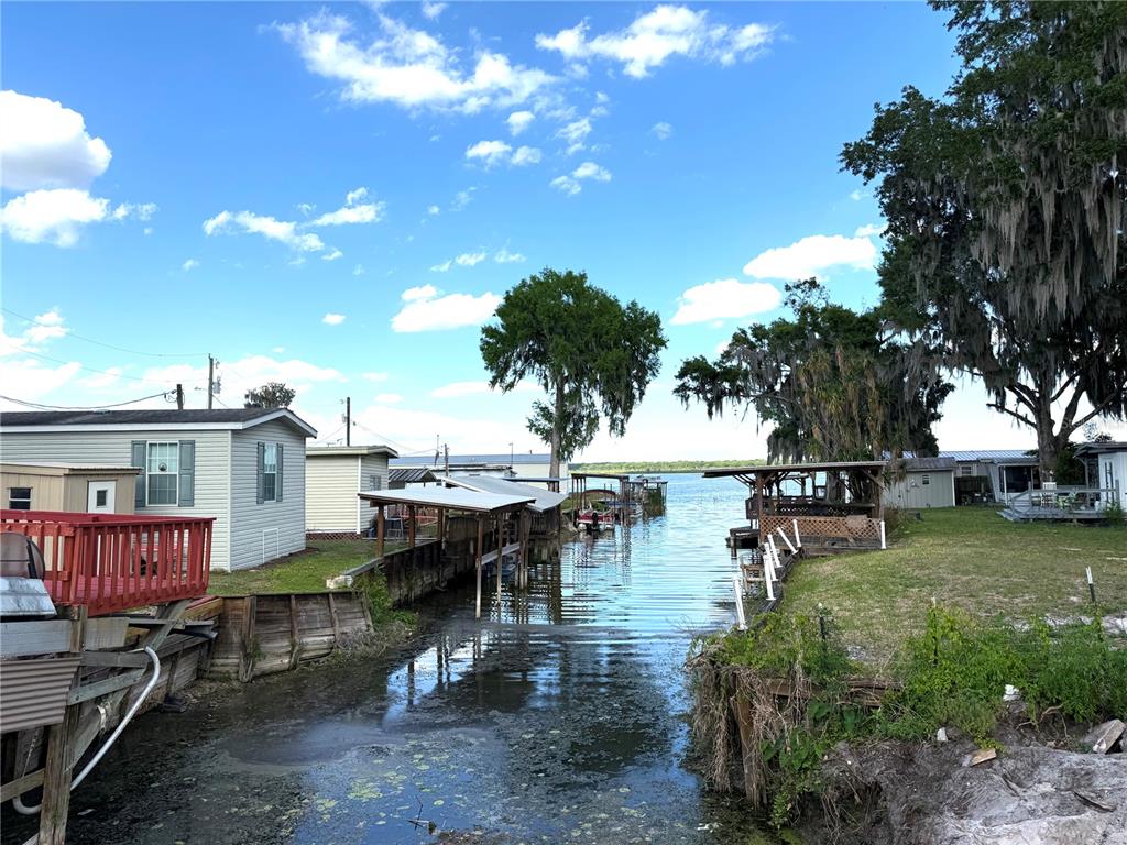 A canal leads from a residential area with mobile homes toward a large open lake — 748 CR 477A, LAKE PANASOFFKEE, FL