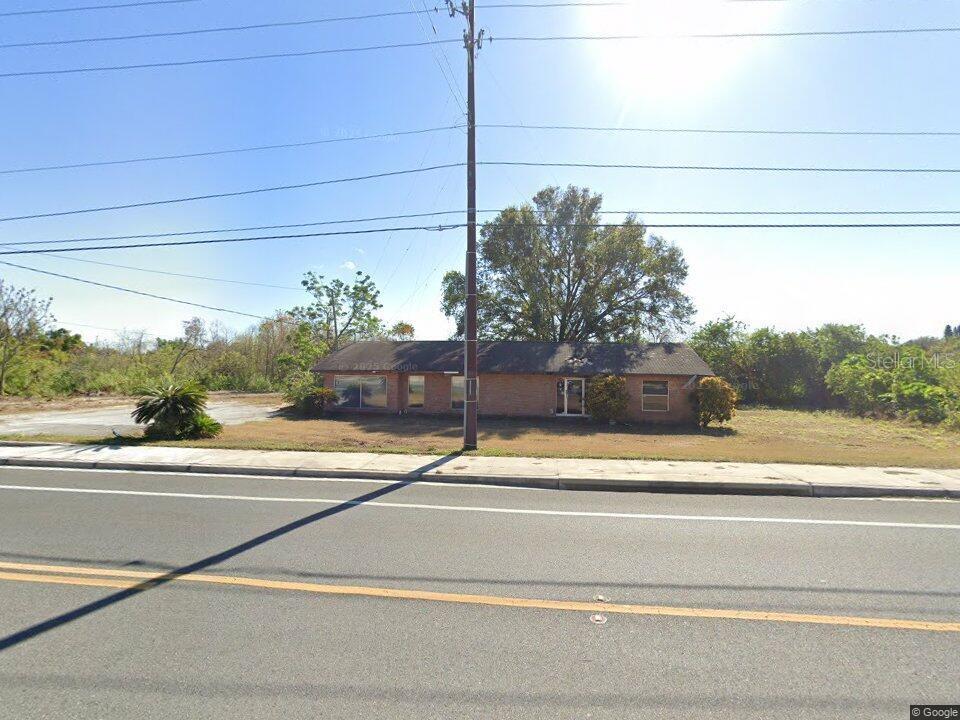 A single-story brick building sits on a grassy lot next to a paved road — 1505 DUNDEE ROAD, WINTER HAVEN, FL