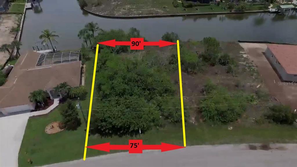 An aerial view shows a vacant, rectangular waterfront lot marked with dimensions of 75 and 90 feet — 15028 ACORN CIRCLE, PORT CHARLOTTE, FL