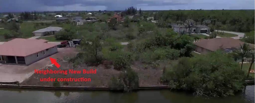 An aerial view of a waterfront lot with a neighboring house under construction — 15028 ACORN CIRCLE, PORT CHARLOTTE, FL