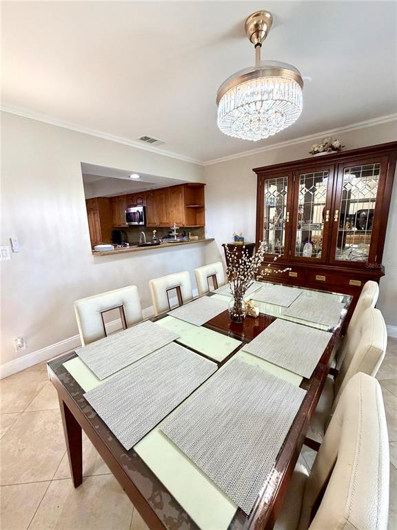 A dining room features a glass-topped table, upholstered chairs, and a crystal chandelier — 6075 GLENDALE DRIVE, BOCA RATON, FL