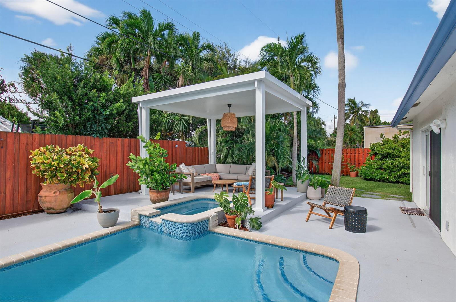 A backyard features a swimming pool, a raised spa, and a covered patio with seating — 802 Mallard Drive, Delray Beach FL 33444, DELRAY BEACH, FL