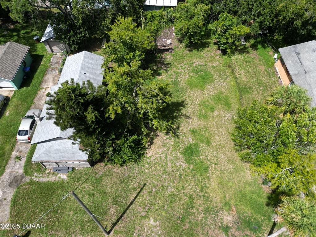 An aerial view shows a residential property with a house, driveway, and large backyard — 724 STATE AVENUE, DAYTONA BEACH, FL