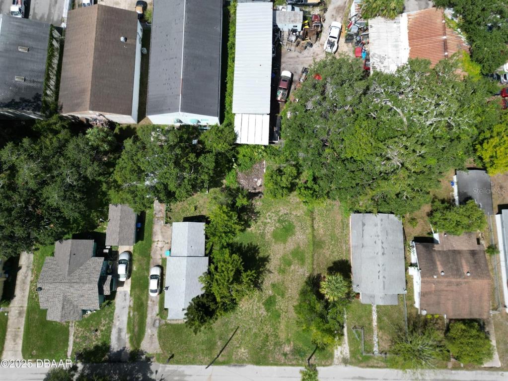 An aerial view shows several residential buildings and a vacant lot with trees — 724 STATE AVENUE, DAYTONA BEACH, FL