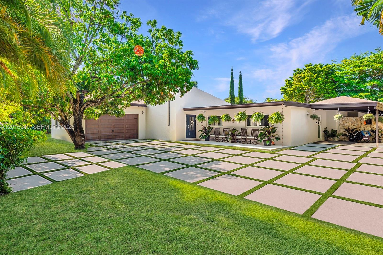 A gated driveway leads to a single-story house framed by two large palm trees — 7650 SW 128th St, Pinecrest FL 33156, PINECREST, FL